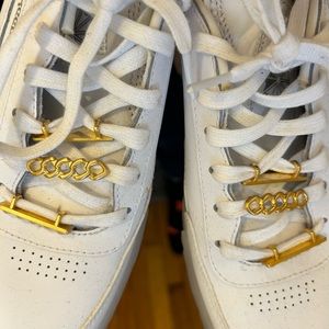 white cardi b reeboks with gold accents